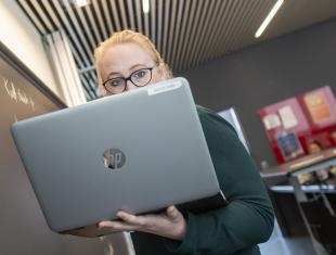 Lærer fra IBC står ved tavlen og skriver af efter computeren