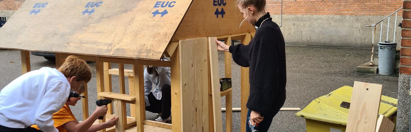 UNGE ARBEJDER PÅ TRÆHUS 